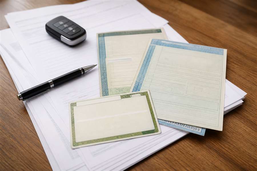 Documentos sobre uma mesa representando a transferência de veículo